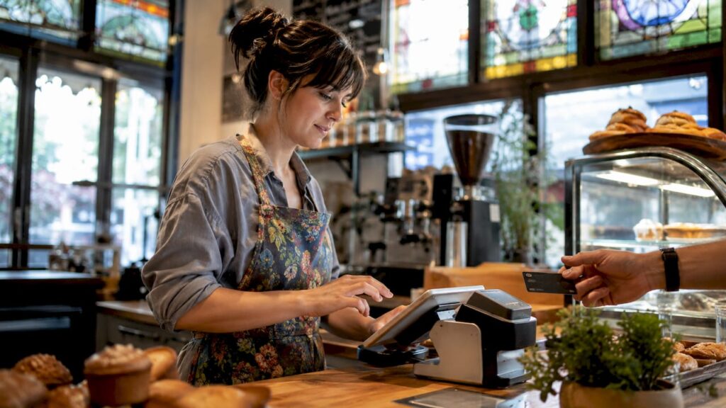 Barista processing café payment at counter